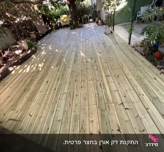 דק עץ בגינה עם עצים מסביב